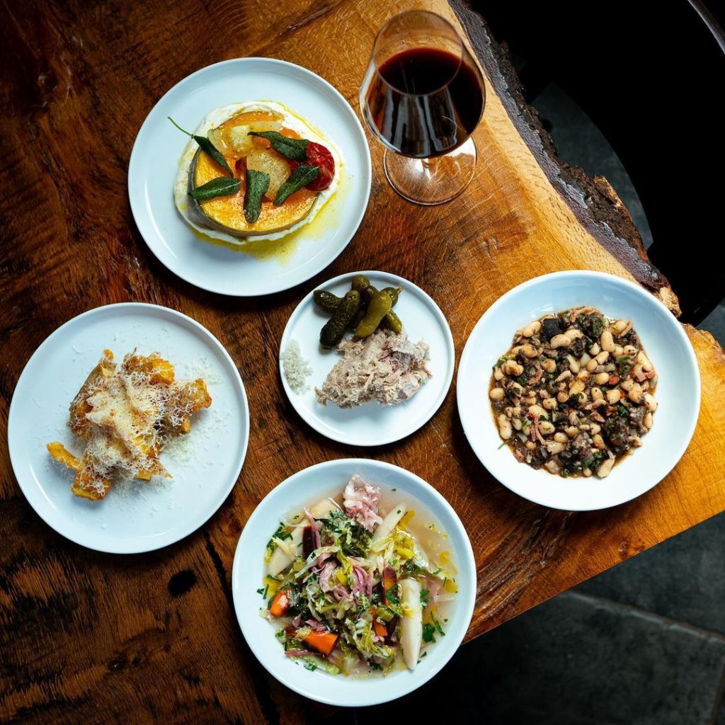 An array of British-European small plates laid out on a wooden table at COIN, Hebden Bridge. 