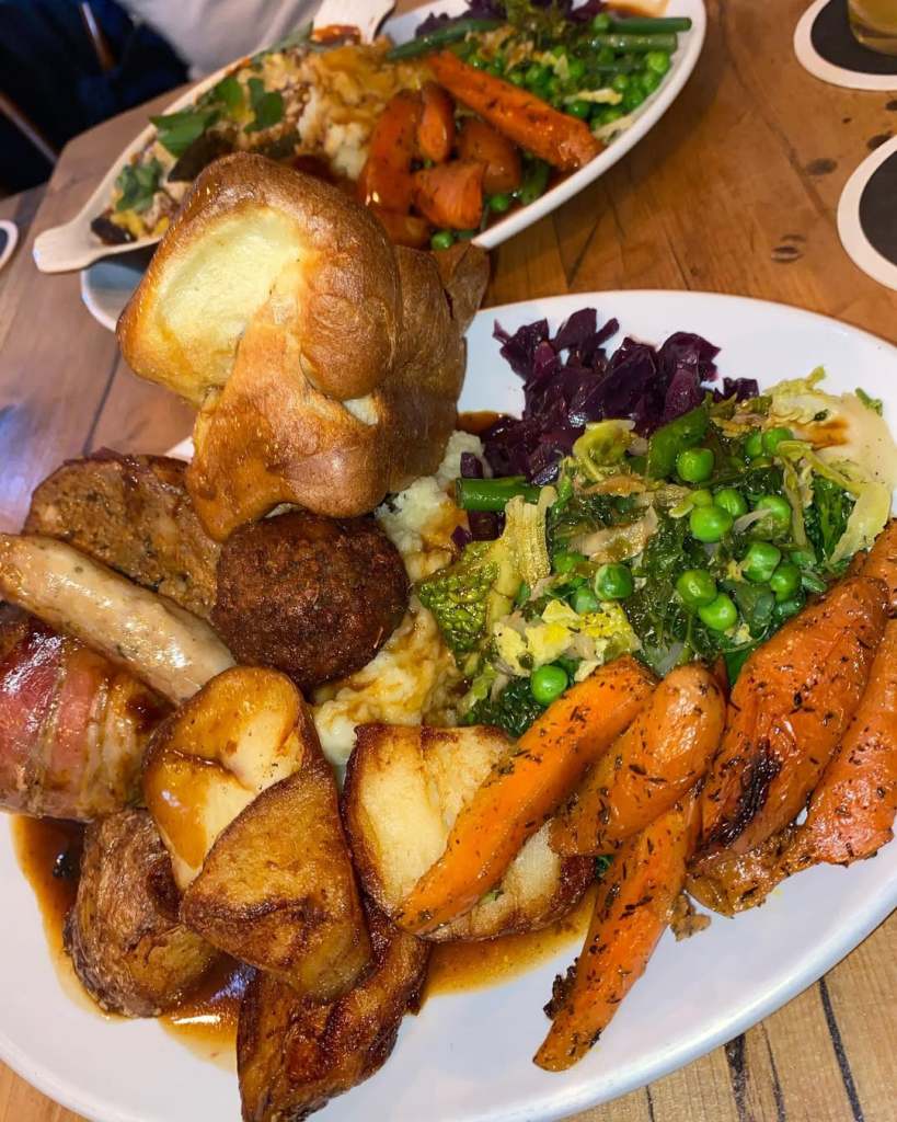 Sunday roast served on a table piled high with vegetables. 