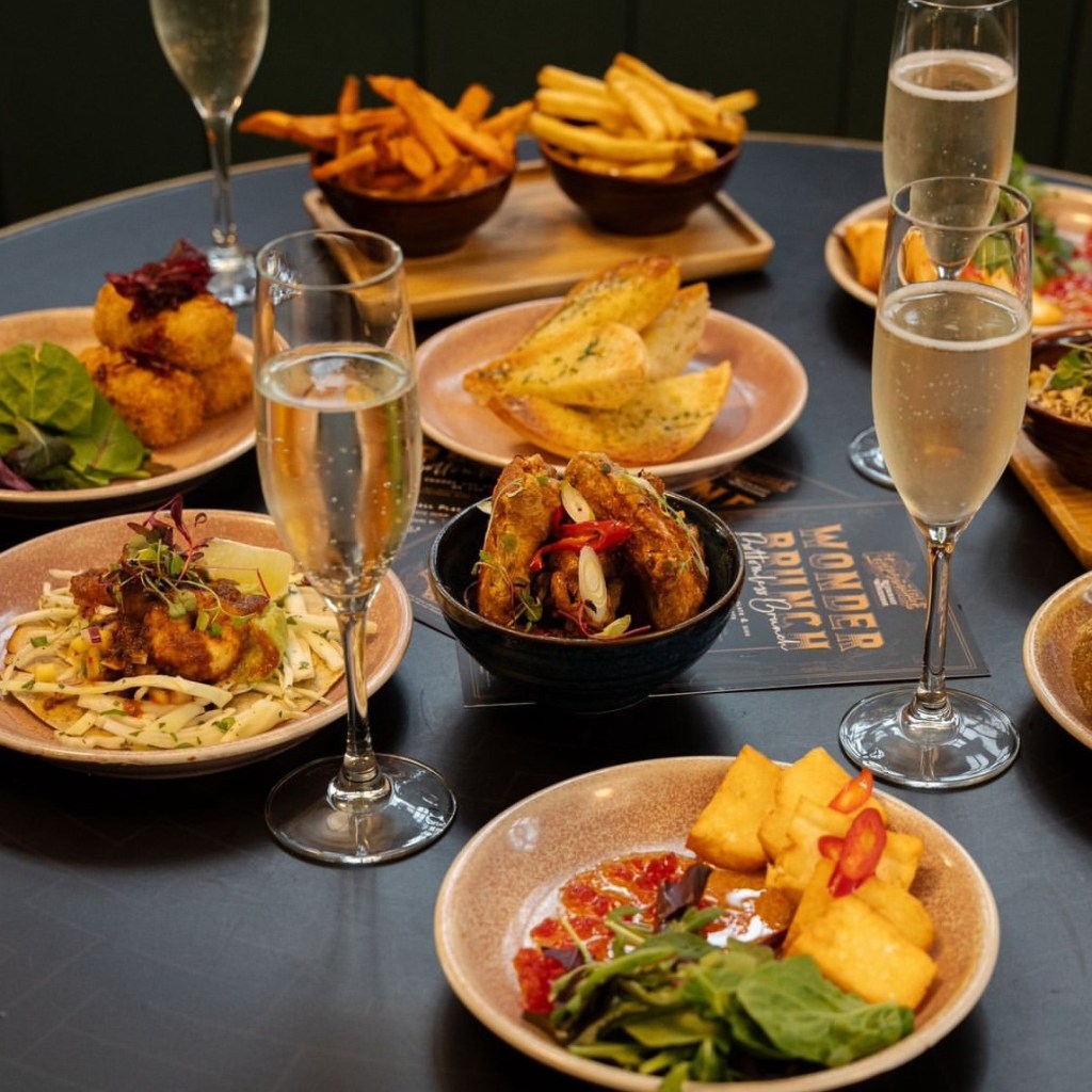 Food served on a table with prosecco at Impossible, York. 