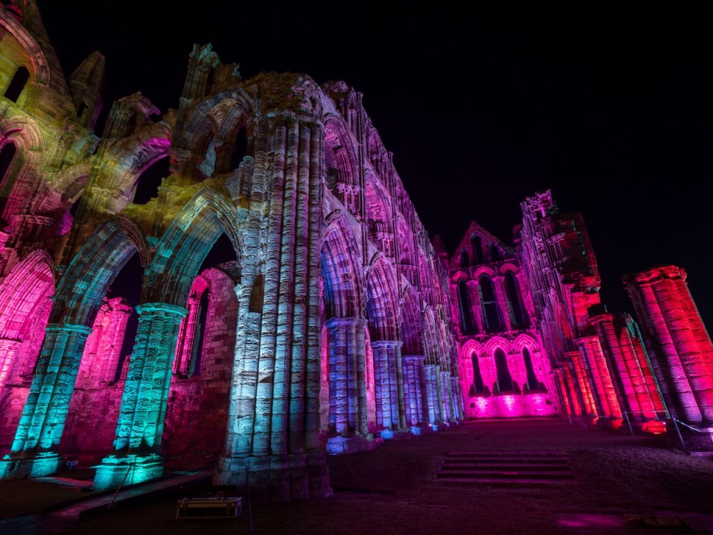 Whitby Abbey illuminated with rainbow lights. 