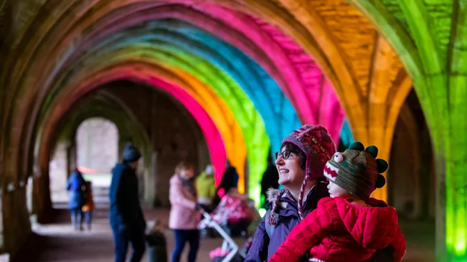 Fountain's Abbey lit by rainbow lights. 