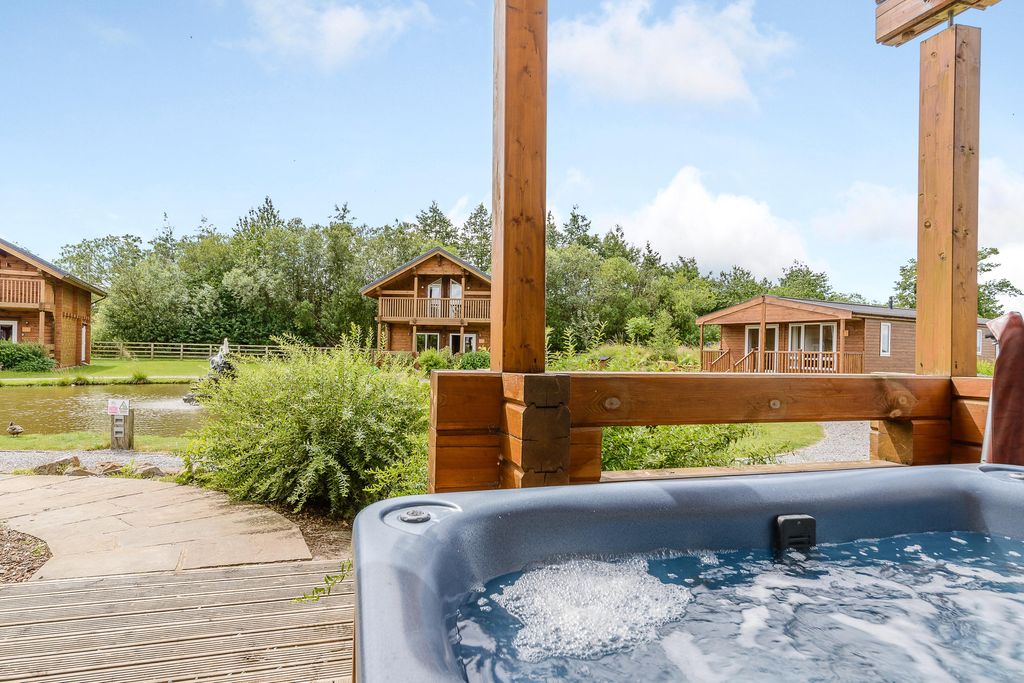 View of hot tub and lodges at Landal Woodland Lakes in Thirsk. 