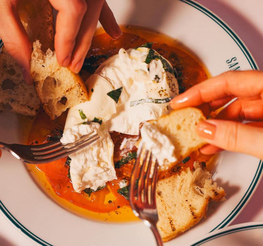 San Carlo's Burrata starter, being spread onto bread. 