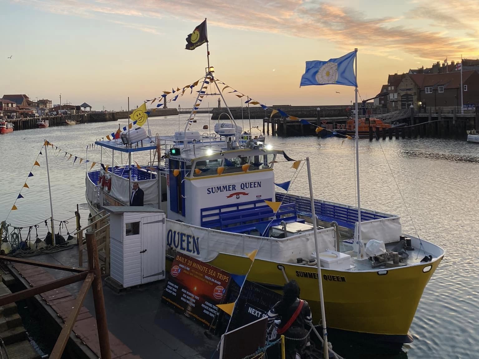 Whitby Coastal Cruise's boat docked at Whitby as the sun sets. 
