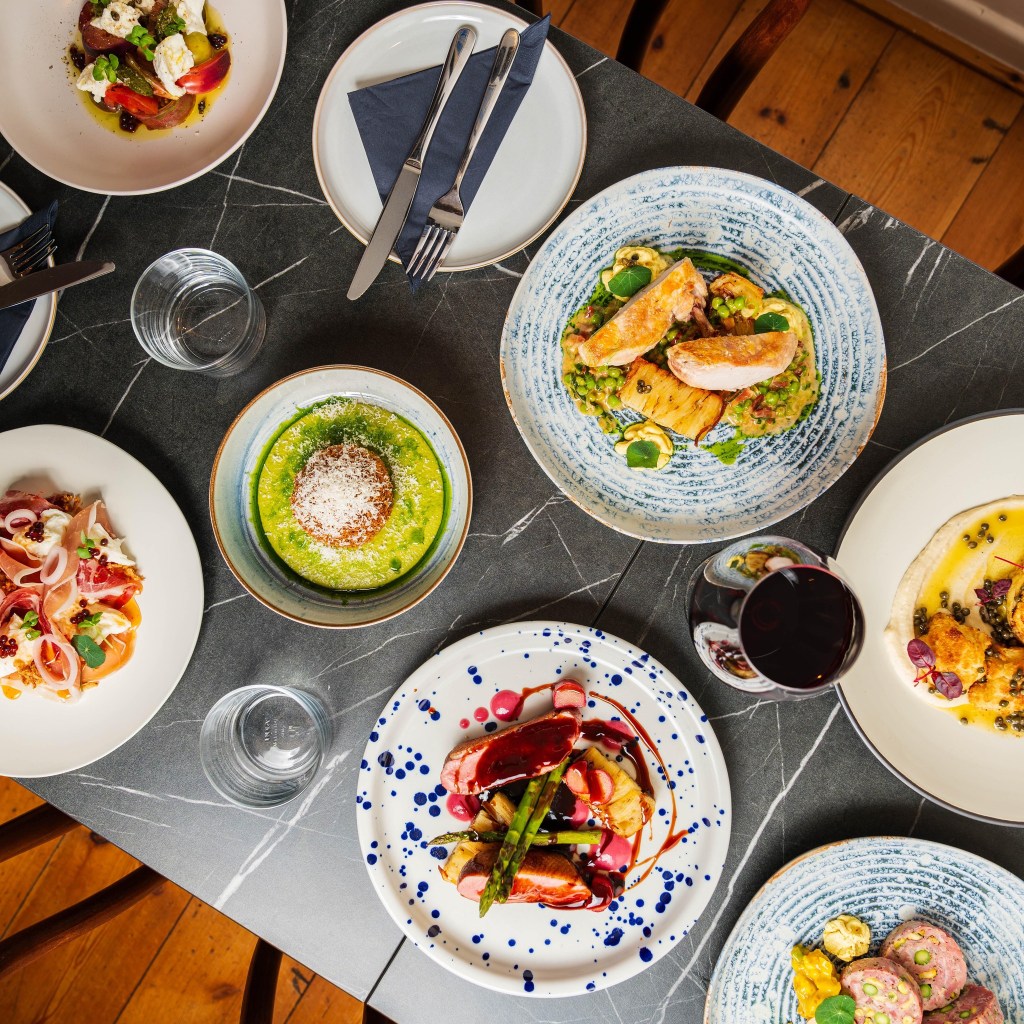 A bird's eye view of numerous dishes served at a table at Med at Olana, Barnsley. 