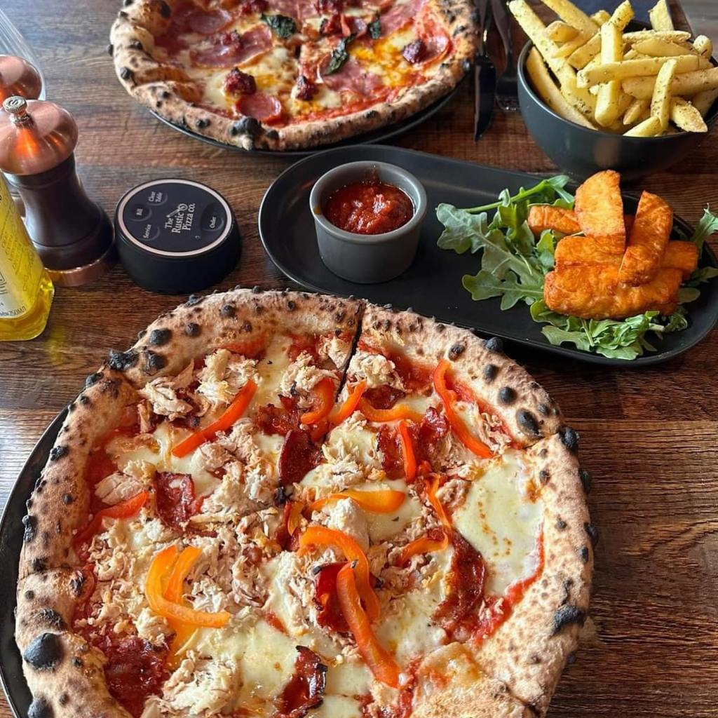 A view of a sliced up pizza on a table. 