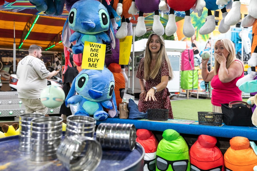 Women playing a fairground game at Summer Beach Club, Meadowhall. 
