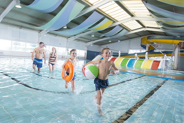 A family playing in the pool at Cayton Bay holiday park.
