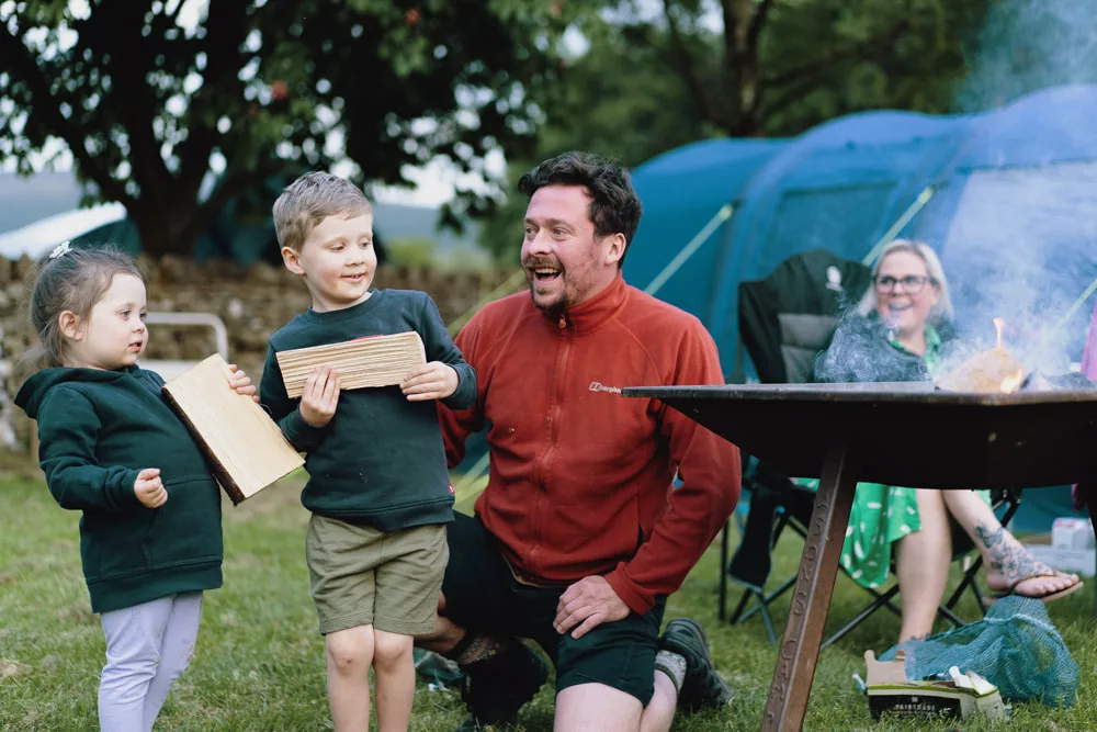 A family gathered around the campfire at Masons Campsite in Yorkshire.
