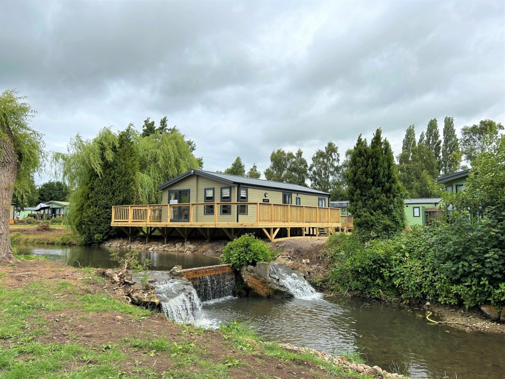 A holiday lodge over a stream at Akebar Park, Yorkshire.